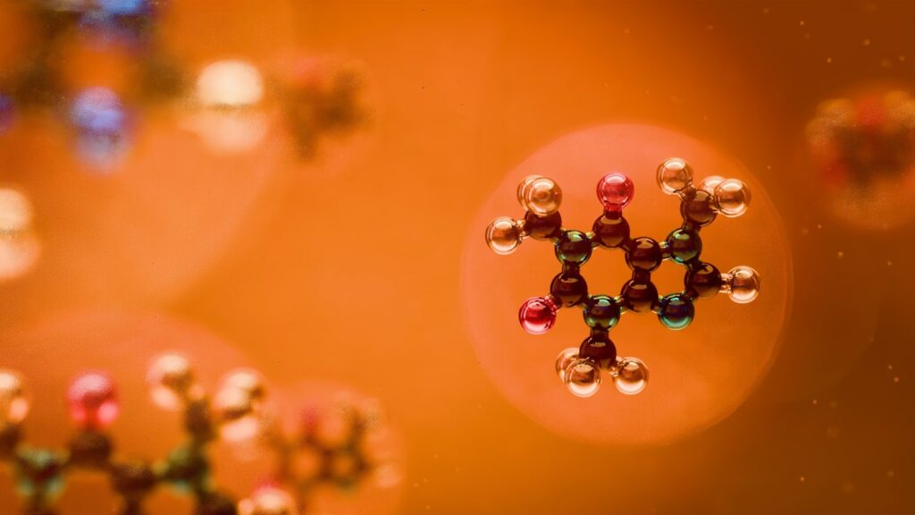 Molecular structures are seen against an orange backdrop.