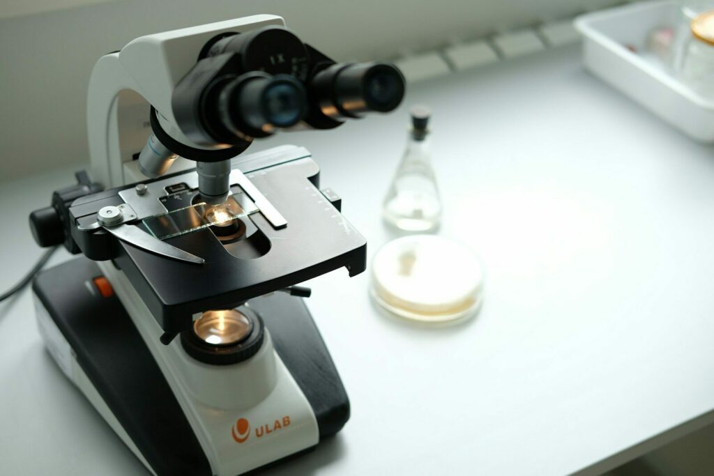 A microscope sitting on top of a table next to a bottle