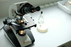 A microscope sitting on top of a table next to a bottle